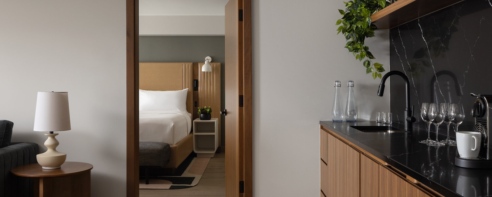 Executive suite includes a modern couch and chair, with a coffee table and bar