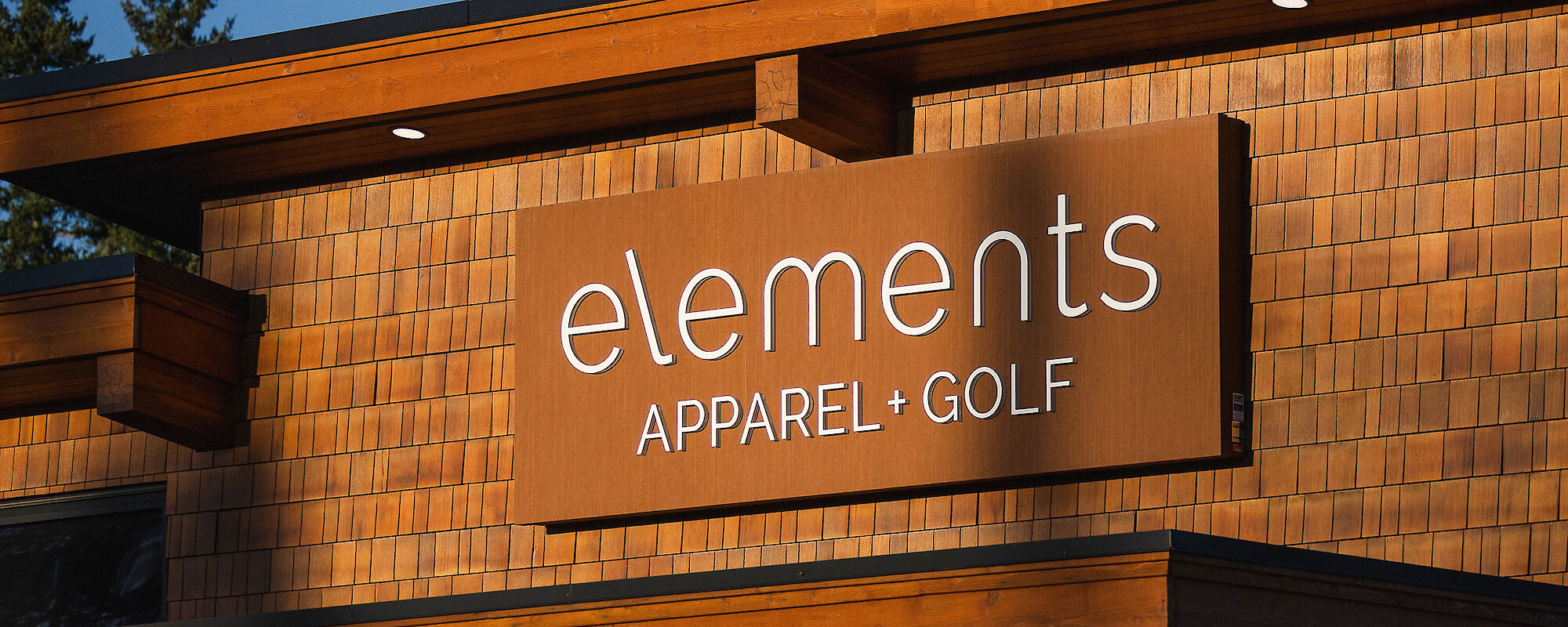 View of Elements Apparel and Golf shop sign as the warm light of the dusk sun shines on it.