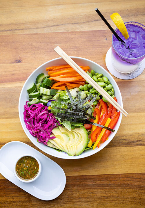 A bright and vibrant rice bowl topped with lots of vegetables