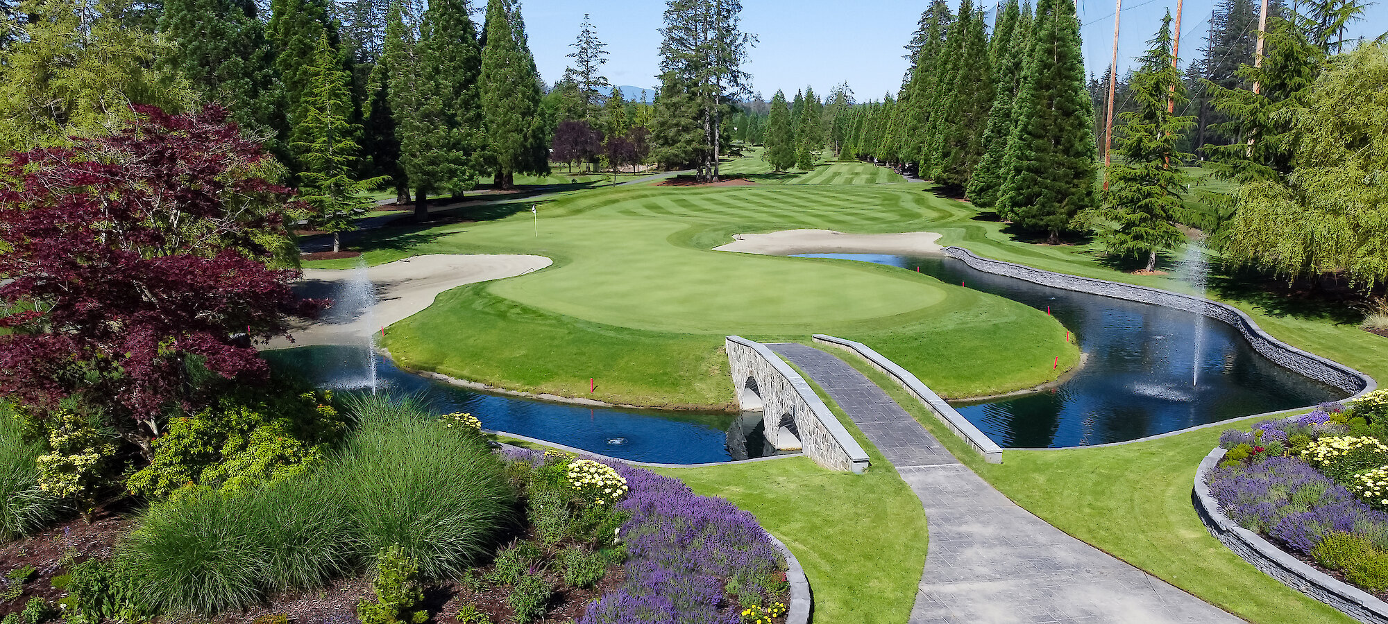 hole 18 is almost an island of green, surrounded by a water feature with two fountains, and lush gardens as well as a bridge to walk over to get off the green