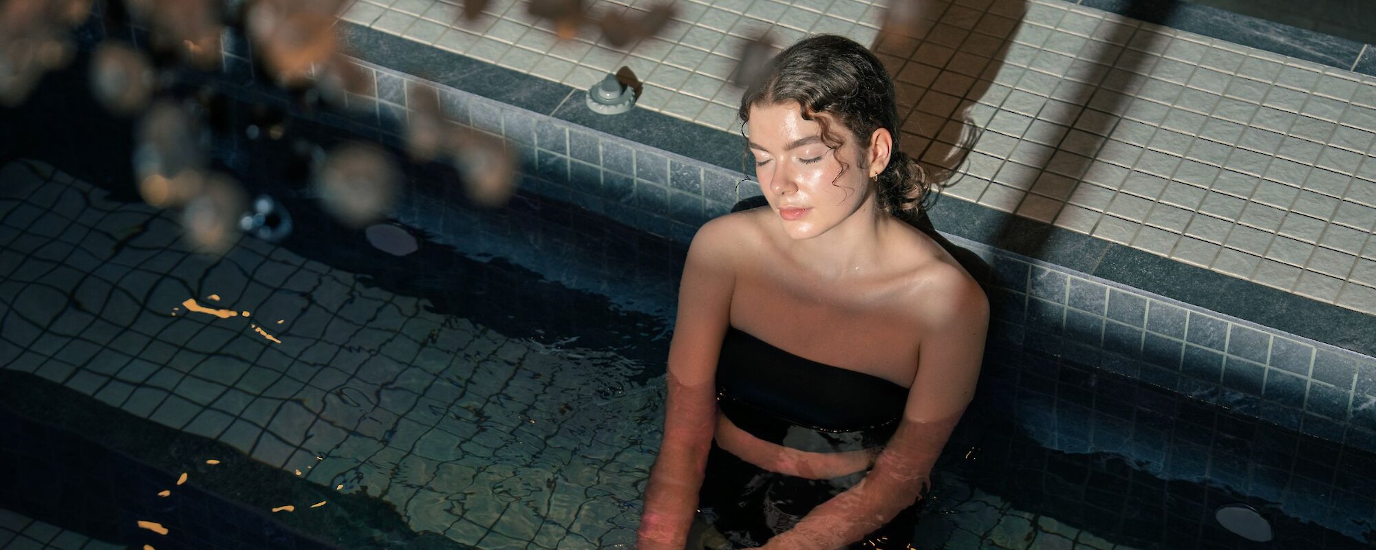 mineral pool and experience showers with a beautiful chandelier over the pool and loungers to the side