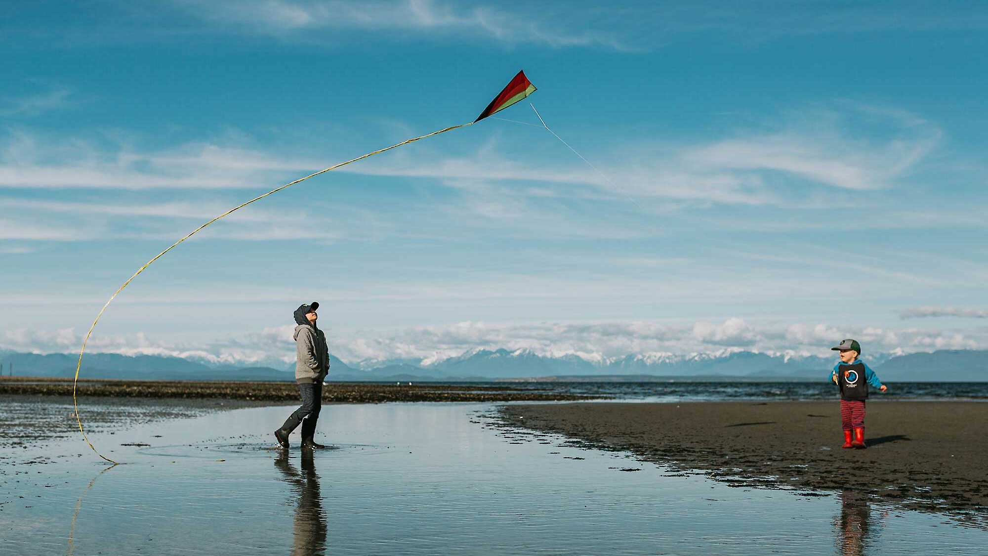 Two young children play with their kite on Saratoga Beach